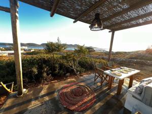a table and chairs on a patio with a view of the ocean at Antiparos Private House Agios Georgios in Antiparos