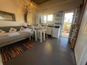 a living room with a couch and a table and a kitchen at Antiparos Private House Agios Georgios in Antiparos