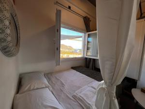 a small bedroom with a bed and a window at Antiparos Private House Agios Georgios in Antiparos