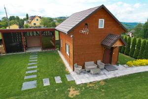 a small house with a patio and a yard at Domek na wzgórzu in Tabaszowa