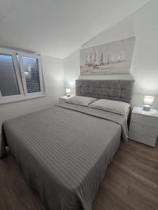 una camera con un grande letto e due finestre di Apartments Ivankovic a Nin Altre 36 foto