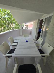 un tavolo bianco e sedie su un balcone di Apartments Ivankovic a Nin