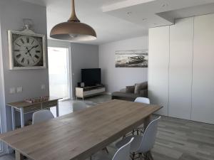 a dining room with a table and a clock on the wall at Blue Bay Beach Apartment in Sesimbra
