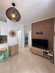 a living room with a flat screen tv on a entertainment center at Blue Bay Beach Apartment - Maria in Sesimbra +31 photos