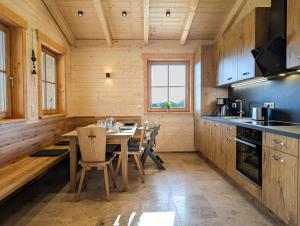 a kitchen with a table and chairs in a room at Gemütliche Chalets & Ferienhäuser mit Kamin und Sauna im bayrischen Wald in Brennberg