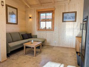 a living room with a couch and a table at Gemütliche Chalets & Ferienhäuser mit Kamin und Sauna im bayrischen Wald in Brennberg