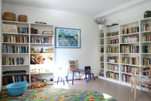 a room with white book shelves filled with books at Anka in Władysławowo