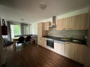 a kitchen with wooden cabinets and a table and chairs at Ferienhäuser vom Freizeitpark Possen in Sondershausen
