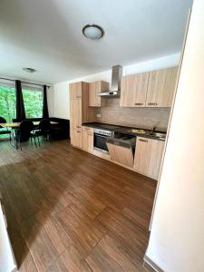 a kitchen with wooden cabinets and a table and chairs at Ferienhäuser vom Freizeitpark Possen in Sondershausen +31 photos