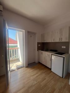 um quarto vazio com uma cozinha com uma grande janela em Vasiljević apartmani em Igalo mais 11 fotografias