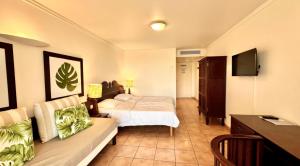 a hotel room with a bed and a couch at Studio Ti Paradis in Sainte-Luce