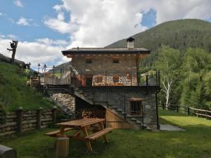 a building with a picnic table in front of it at Chalet Cuore Selvatico in Monno