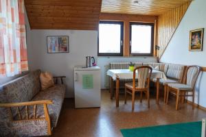a living room with a couch and a table and chairs at Pension Eger in Treuchtlingen