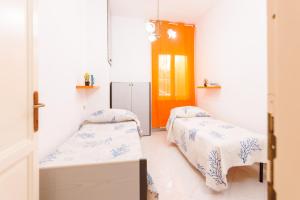 une chambre d'hôpital avec deux lits et une porte orange dans l'établissement Sea La Vie, 5 minuti dalla Cinta, à San Teodoro