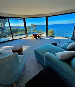 シドニーにあるOcean view home South Coogeeの海の景色を望むリビングルーム(青いソファ付)