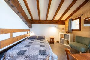 a bedroom with a bed and a chair in a room at Studio 18 - Le Chamois in Crest-Voland