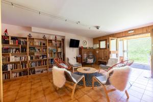 a living room with a table and chairs and book shelves at Studio 18 - Le Chamois in Crest-Voland