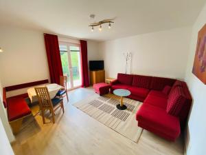 a living room with a red couch and a table at Villa Mira in Klopein am Klopeiner See