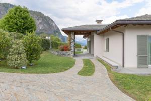 a house with a stone walkway next to a house at Villa Miraggio by MyVillaCollection in Tremezzo