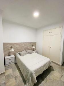 a bedroom with a large bed and two night stands at Córdoba 8 by 7Escalones in Rota