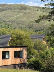 a house on the side of a hill at 1 Bedroom Cabin with Mountain & Loch Views - Quiet Location between Glencoe & Ben Nevis in Corran +35 photos