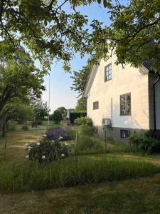 a white house with flowers in the yard at Village house & garden for summer hangout near Sankt Olof in Onslunda +17 photos