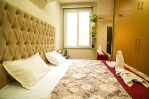 a bedroom with a large bed with a large headboard at Rose Manor suites in Dehradun