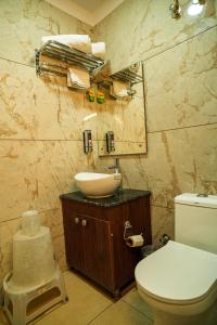 a bathroom with a white toilet and a sink at Rose Manor suites in Dehradun +23 photos