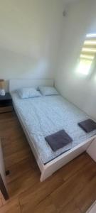 a bed in a white room with a window at Domek Herada 2 in Jastarnia