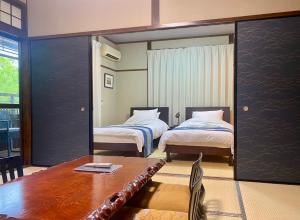 a hotel room with two beds and a table and a dining table at Good Stay Mizuho in Usa +38 photos
