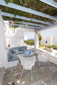 a patio with a couch and chairs and a table at Villa Maria, Golden Beach, Paros in Kampos Paros