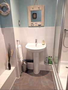 a bathroom with a sink and a shower at Chichester City Centre 2 Bedroom Flat I Ground Floor with Underground Parking I Chichester Holiday Properties in Chichester +52 photos