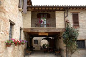 a building with a balcony with chairs and flowers at Agriturismo Il Borghetto in Montefalco