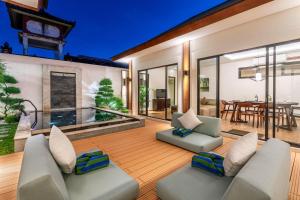 an outdoor living room with chairs and a table at Oasis Residences Sanur - Family-Friendly 3-BR Villa with Private Pool & Garden in Sanur