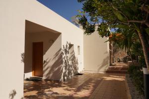 an external view of a white house with a courtyard at House of Harmony Standaard studio Mira ADULTS ONLY in Achlada +8 photos