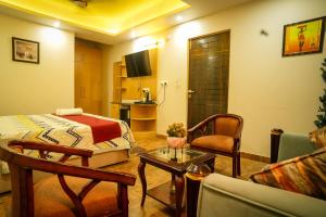 a hotel room with a bed and a living room at Rose Manor suites in Dehradun