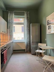 a kitchen with a refrigerator and a table and a window at CLS Große City Altbau Wohnung für 4 Personen mit XXL Dusche, neues Bad, Dielen, Schlafsofa 160x200 mit 20cm Matratze, Smart TV & schnellem WLAN in Hildesheim Ost, Nähe HAWK, Uni, Bosch, Ostbahnhof, A7 in Hildesheim +20 photos