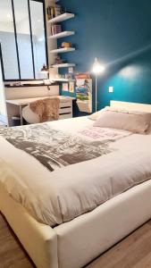 a large white bed in a room with a desk at Villa avec piscine et magnifique jardin ! Villa with swimming pool and magnificent garden! in Aigrefeuille-sur-Maine