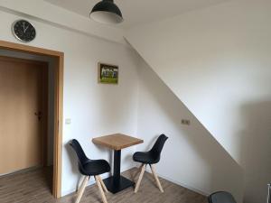 un tavolo e sedie in una stanza con scala di NEU! Ferienwohnung am Grimnitzsee a Joachimsthal