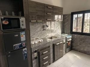 a kitchen with a sink and a refrigerator at Le carrefour de l'apaisement in Pikine