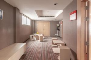 a waiting room with benches and tables in a building at Hi Hotel in Makkasan
