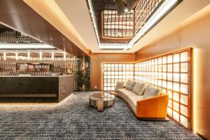 a lobby with a couch and a coffee table at Hi Hotel in Makkasan +11 photos
