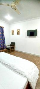 a room with a bed and a chair in it at Greenoriva Aero Srinagar in Srinagar
