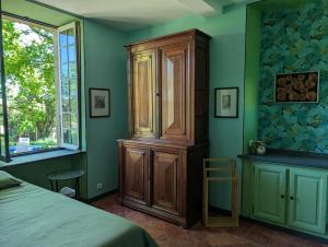 a bedroom with a wooden cabinet and a window at Repos à Touja in Couloumé-Mondébat