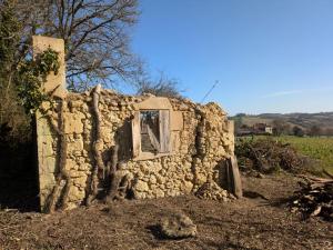 an old stone building with a window in a field at Repos à Touja in Couloumé-Mondébat