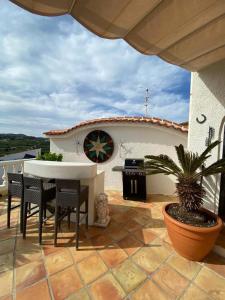 コンブレ・デル・ソルにあるLarge villa, great view with private swimming poolの建物の前にパティオ(テーブル、椅子付)
