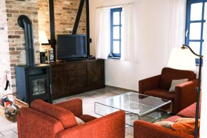 a living room with two chairs and a fireplace at Landhaus 3 Stettinerhaff in Dargen
