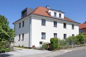 a white building with a red roof at Ferienwohnung Skyline Suite in Bayreuth