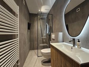 un bagno con lavandino, water e specchio di Hótel Laugarvatn a Laugarvatn