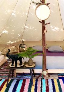 a room with a bed and a table with a lamp at Kârma Hôtel in Saint-Genis-les-Ollières
